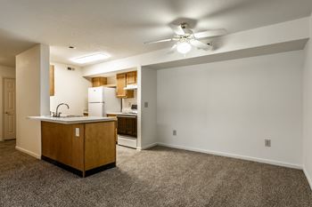 A kitchen with a sink, refrigerator, and a ceiling fan